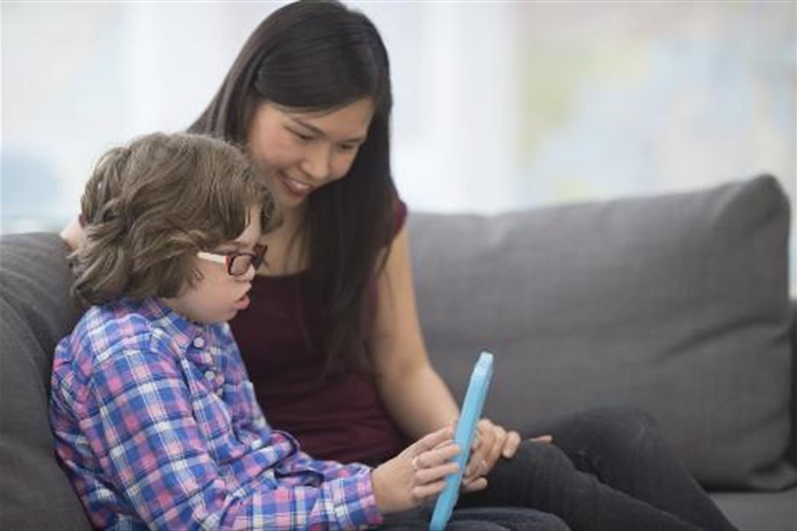 Woman sitting on a couch interacting with young child