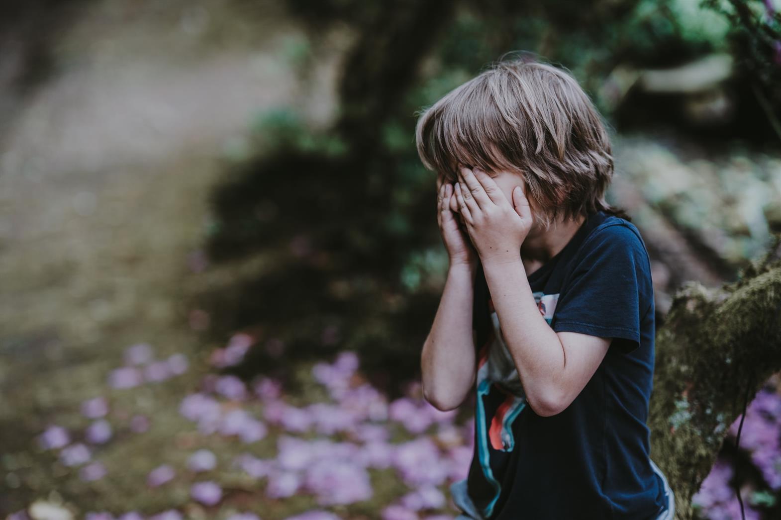 Child covering his face with his hands