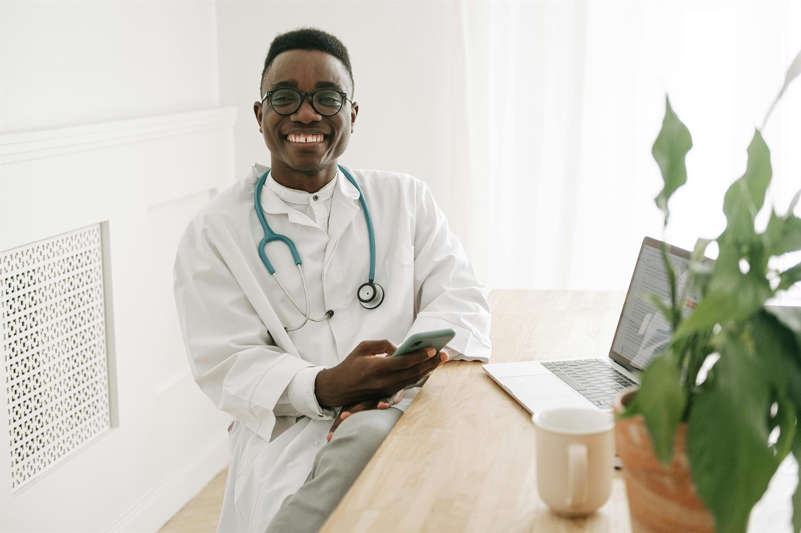 A Smiling Doctor Holding a Smartphone