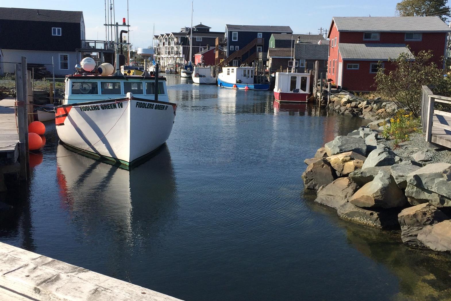 White boat floating next to a dock in Halifax