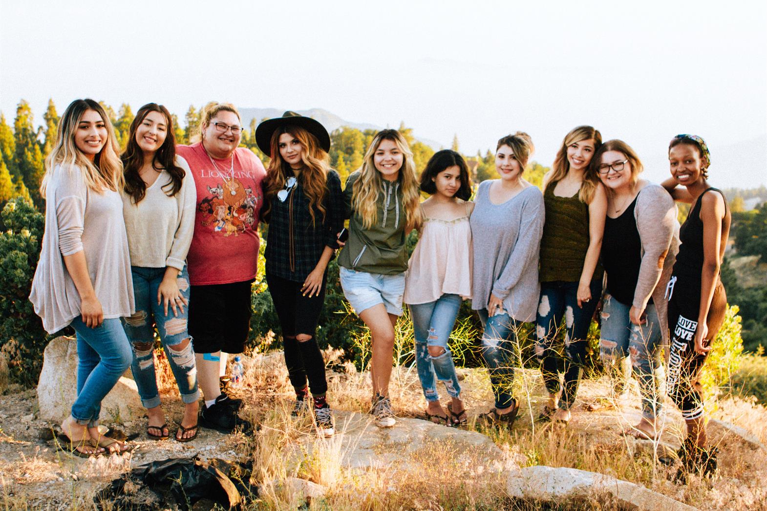 10 young women standing in a row smiling