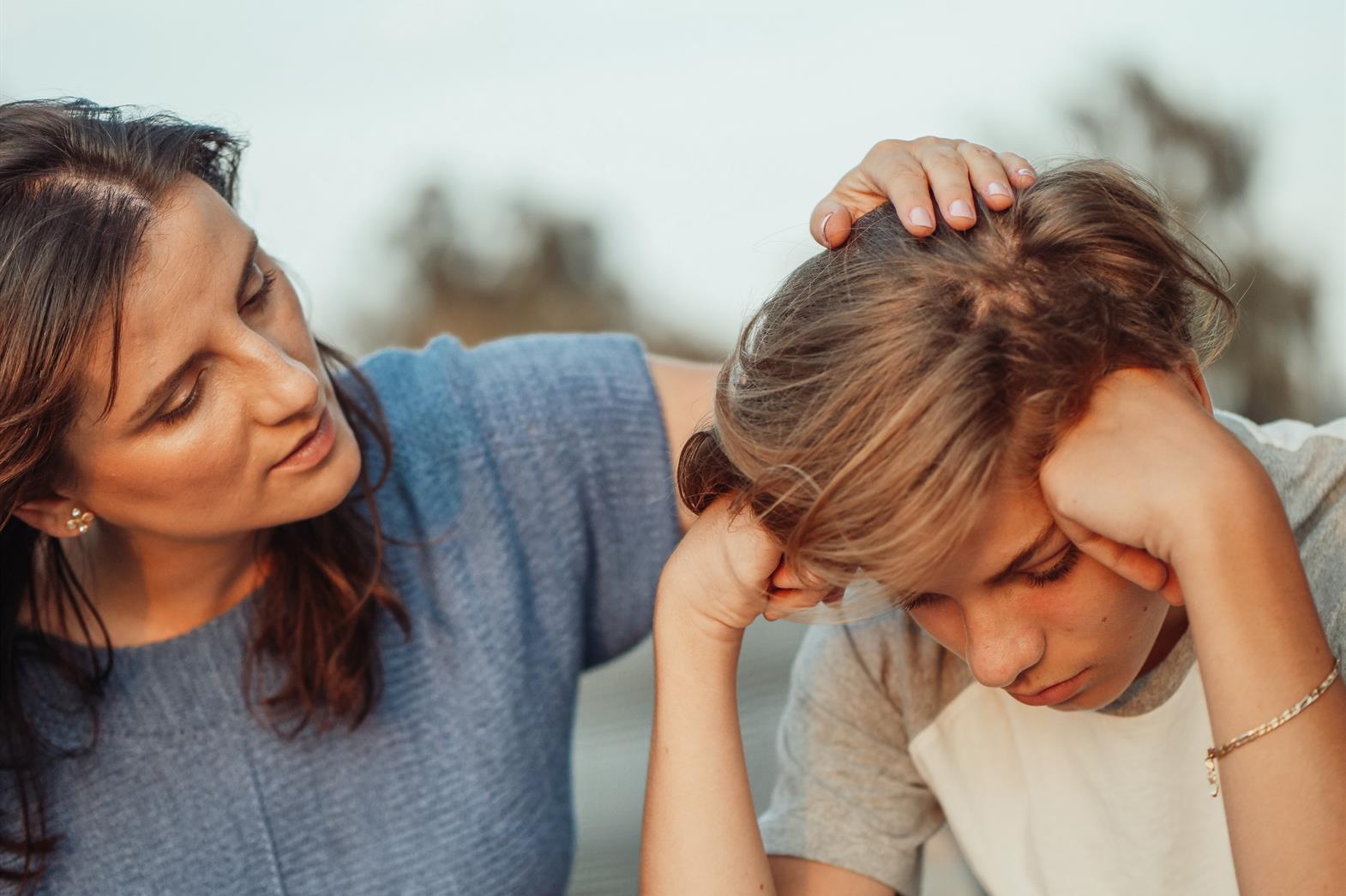 Mother talking to teenage son who looks sad