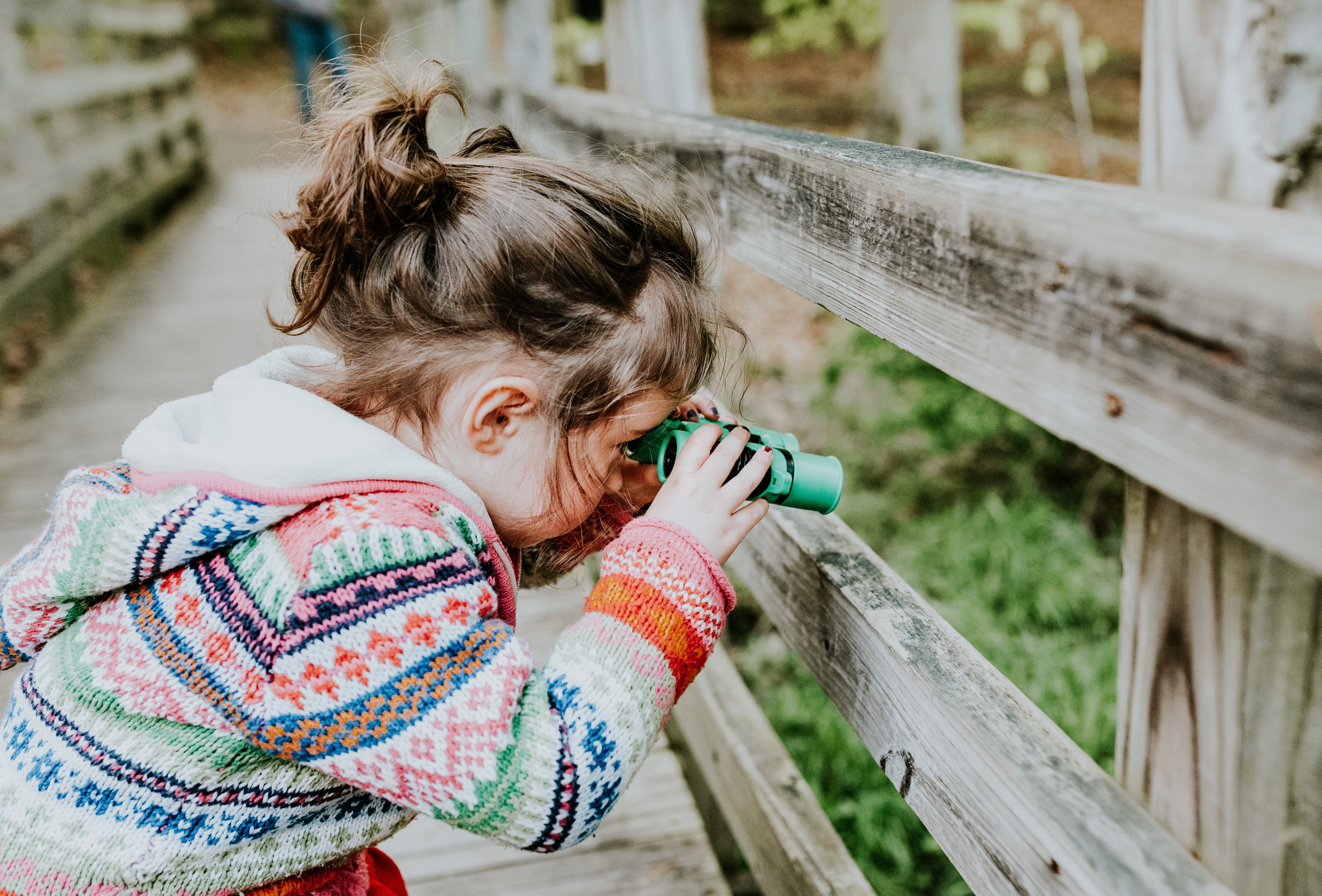 Child looking through toy binoculars