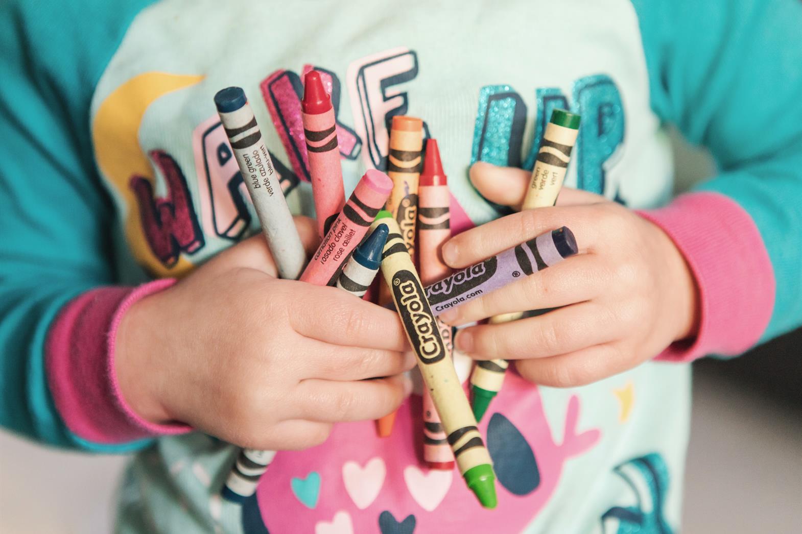 Toddler holding crayons