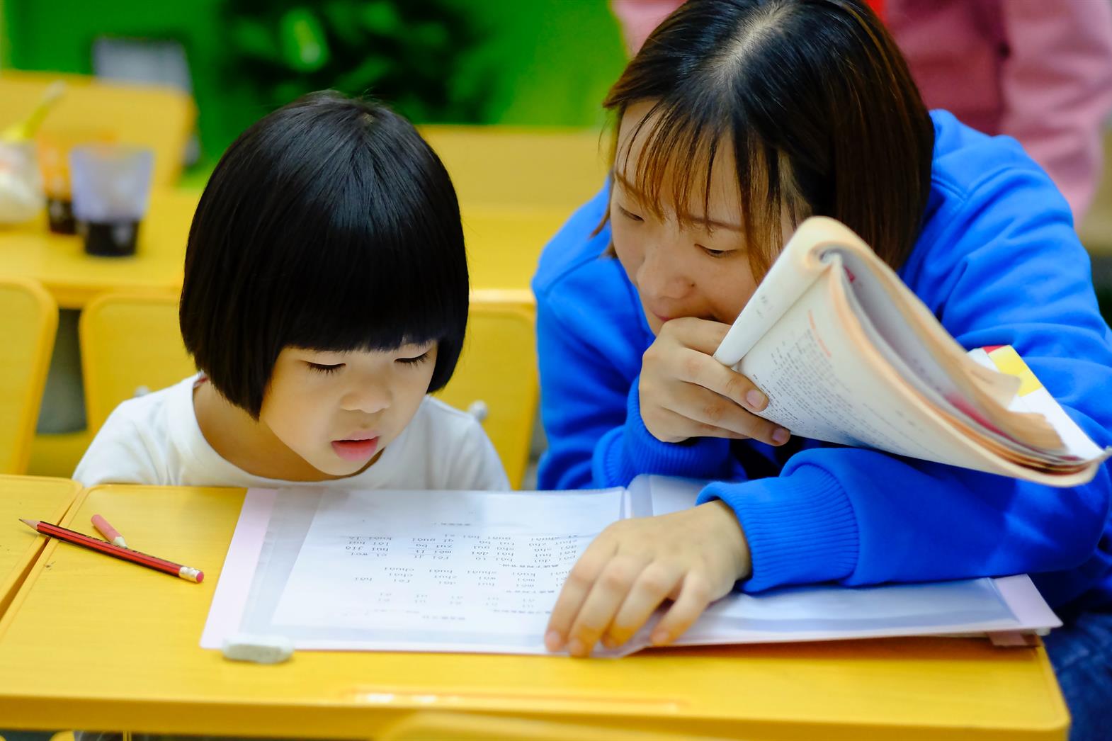 person teaching child in classroom