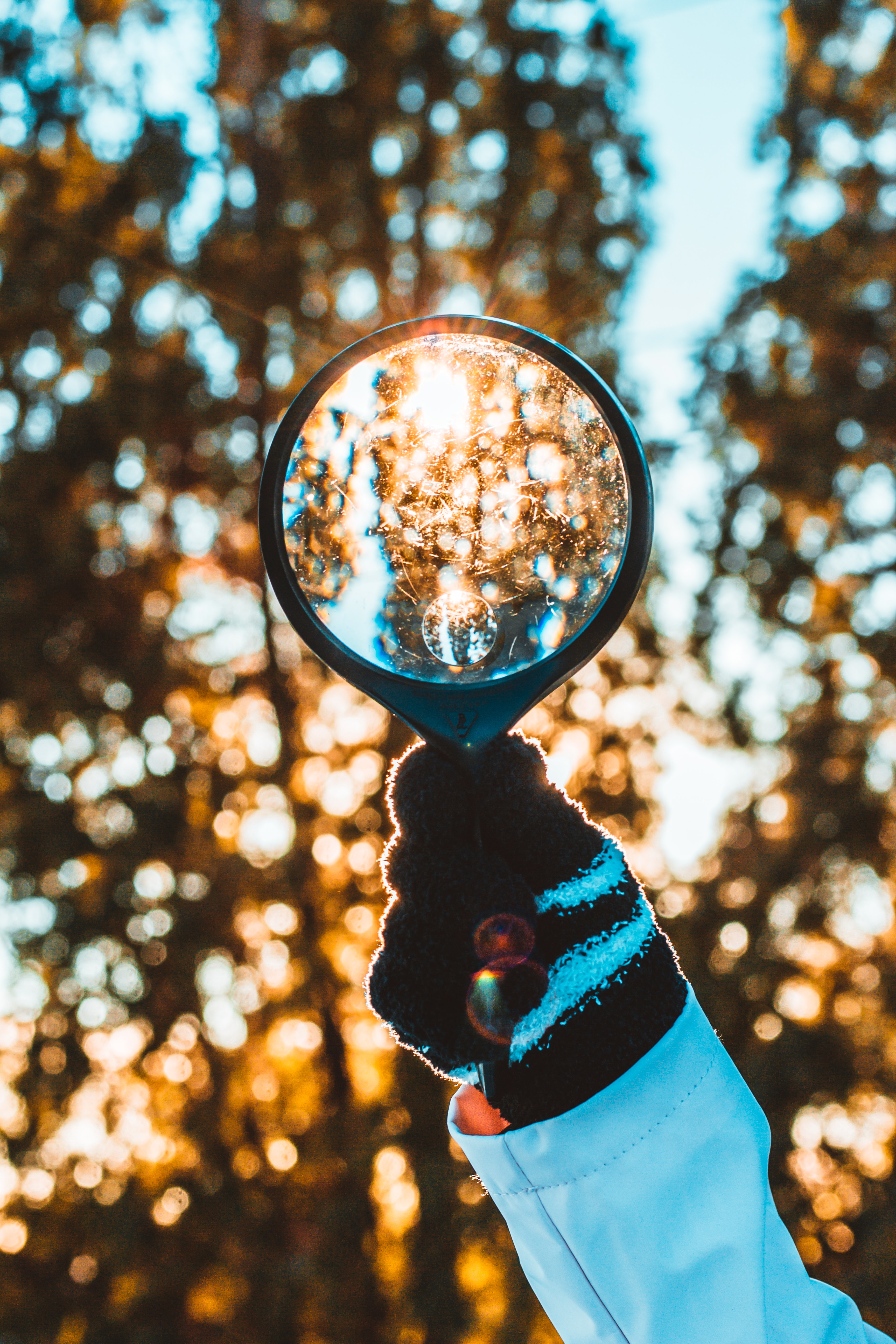 Person holding black magnifying glass